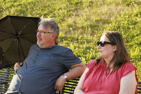 Mies ja nainen istumassa puiston penkillä Ilosaaressa.